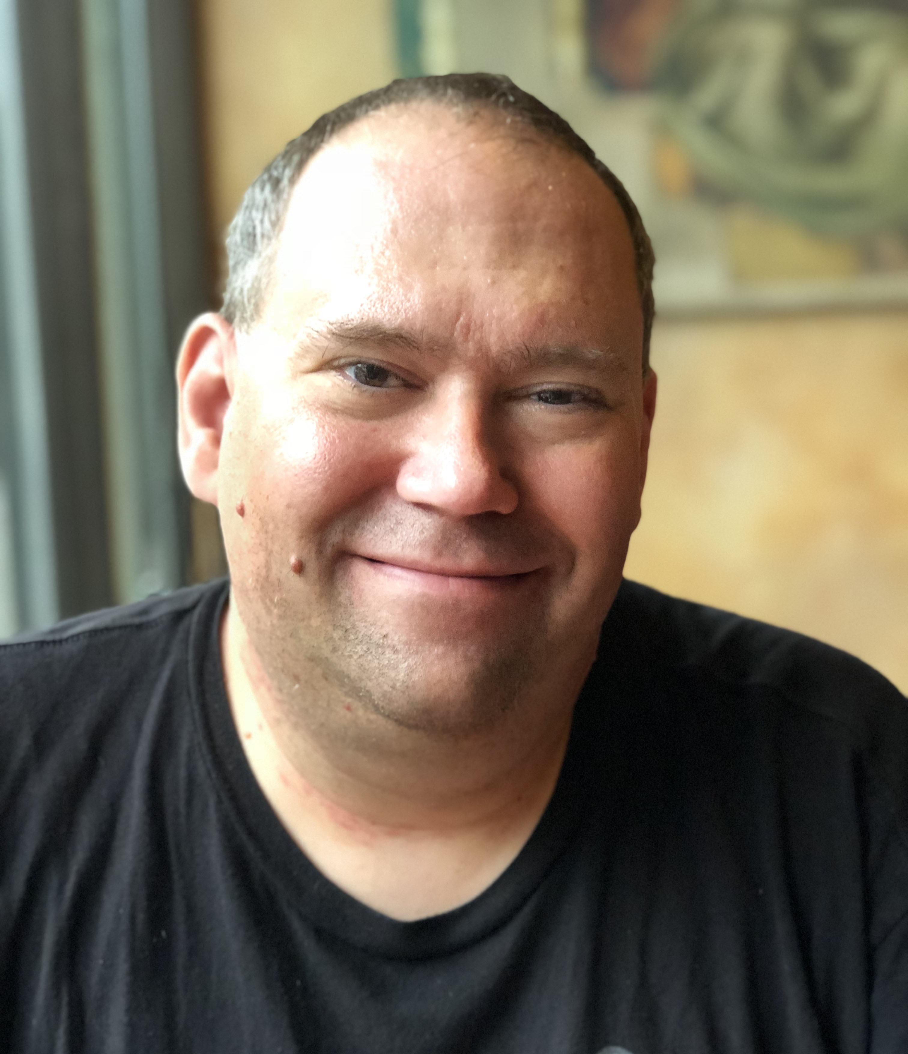 A picture of Pierre Plourde smiling, wearing a black teeshirt.